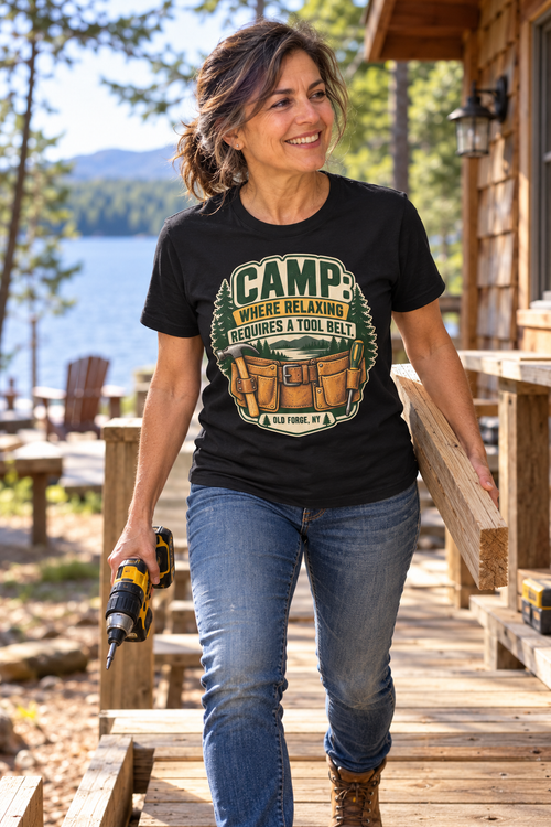 Woman carrying a board and drill at lakeside camp wearing the Old Forge Camp Tool Belt t-shirt