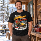Man wearing the blown belt snowmobile cartoon tee beside a snowy cabin