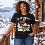 Middle-aged Black woman wearing the Wide Open snowmobile tee on a snowy Adirondack cabin porch