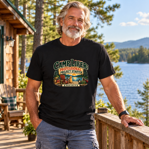 Fit older man with flowing grey hair and beard wearing Camp Lifer tee at an Adirondack lake